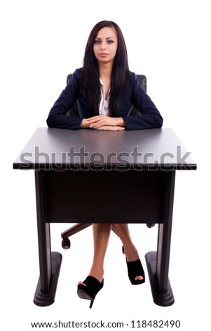 Full length portrait of a beautiful latin businesswoman sitting at desk isolated on white background