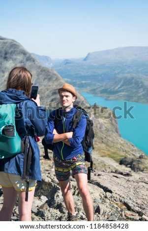 woman taking photo of man on Besseggen ridge in Jotunheimen National Park, Norway 