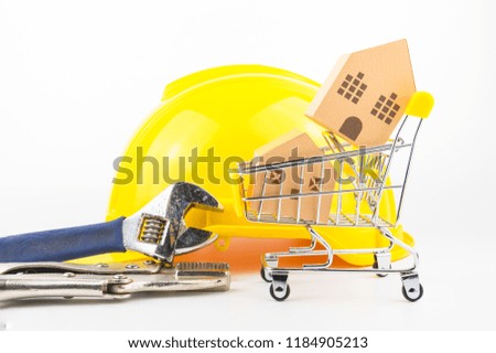 Shopping cart full of paper hose model and construction tools, isolated on white background with copy space.Real estate concept, New house concept, Repair maintenance concept