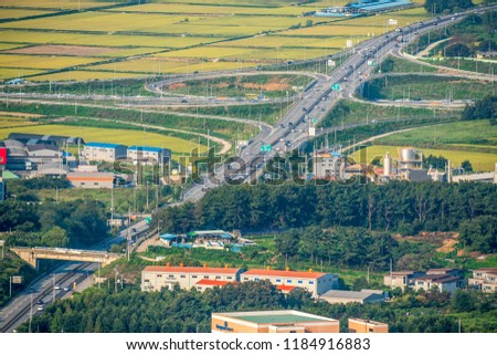 Korea  Asan-si City Aerial view of mountain,Top view of road at downtown of Asan-si highway traffic road .yellow green rice field paddy, South Korea