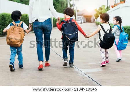 Back to school students mother group going school together. Parent send little boy and girl for first class semester term with schoolbag or satchel together. Collaborative learning and empathy daycare Royalty-Free Stock Photo #1184919346