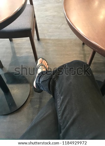 A Man’s legs crossing in a coffee shop during a Meeting