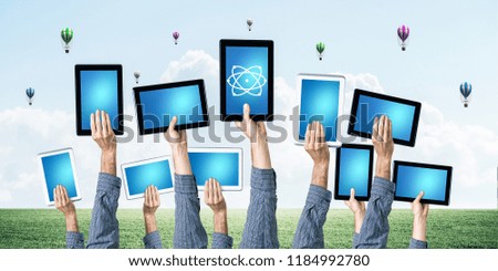 Set of tablets in male hands against nature background and balloons in air