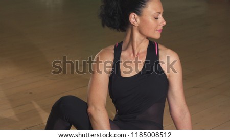Happy gorgeous relaxed woman exercising sitting in yoga asana position smiling