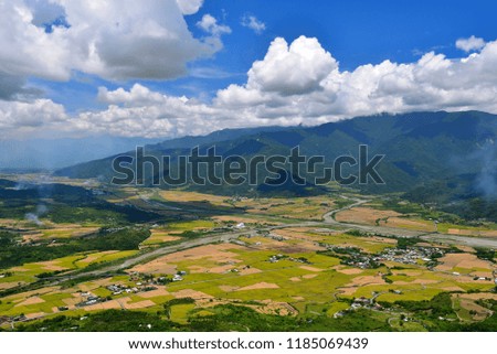 From the height of the mountain and the mountain green paddy fields, some of the harvested paddy fields are yellow land, burning smoke rising up, under the blue sky is very beautiful.