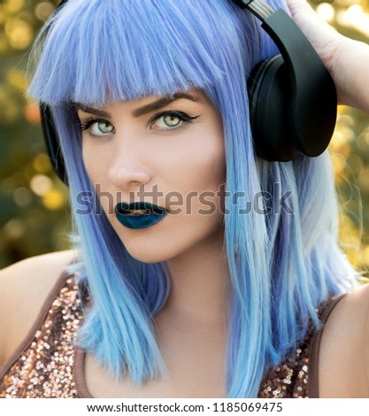 Young woman listening music on headphones close up portrait