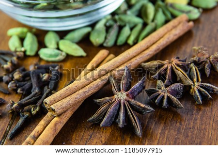 Dry ingredients (star anise, green cardamom, cinnamon sticks, and cloves) for making chai tea.