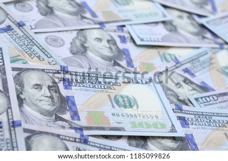 A large number of US dollar bills of a new design with a blue stripe in the middle. Top view