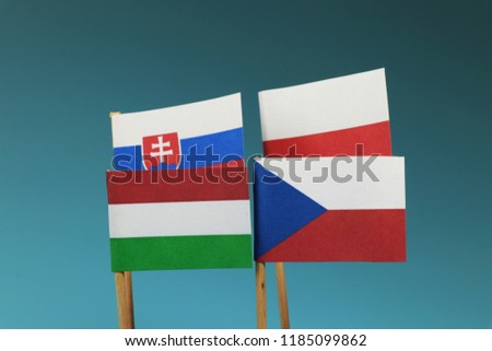 A visegrad four. Czech republic, poland, hungaria, slovakia. Flags on wooden stick. Blue background Royalty-Free Stock Photo #1185099862