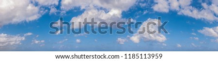 Panorama of peaceful blue sky with puffy white clouds. High resolution panoramic sky.