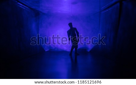 Creepy silhouette in the dark abandoned building. The zombie apocalypse concept or Dark corridor with silhouette of spooky horror zombie standing with different poses.