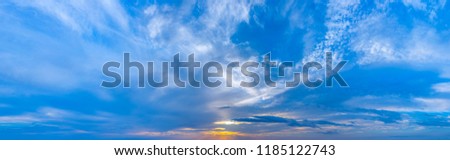 Twilight sunset with colorful clouds. Dramatic atmosphere created by the sunlight. Colorful gradient from blue to orange. Blue sky and clouds. High resolution panoramic sky.