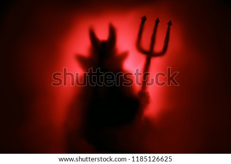Creepy Devil silhouette from hell in the mist with backlit. Royalty-Free Stock Photo #1185126625