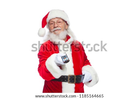 Christmas. Santa Claus in white gloves holding a TV remote control. Browse Christmas TV listings, select the channel. Isolated on white background.