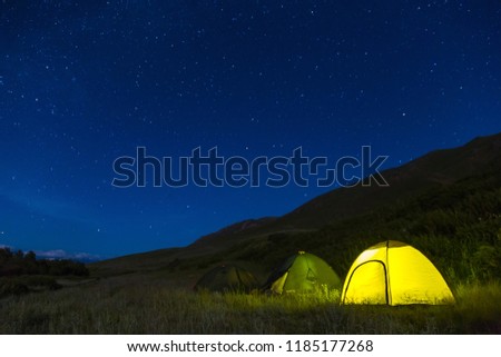 Night camping. Light in tents. The starry sky. A multi-day trip