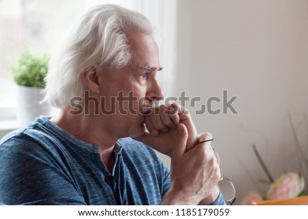 Worried serious mature senior man feeling melancholic anxious about problems making difficult decision, upset thoughtful sad middle aged old male looking away thinking of loneliness and depression Royalty-Free Stock Photo #1185179059