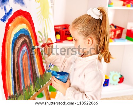Child drawing on the easel at school.