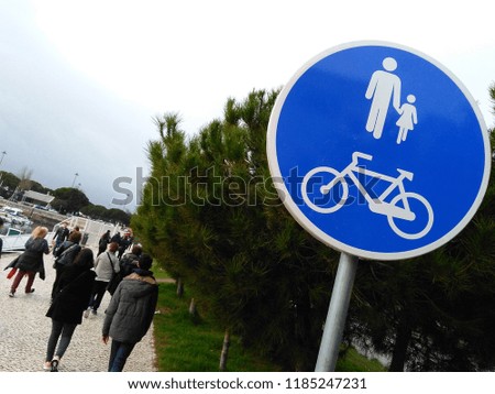 People walk past a bike lane sign