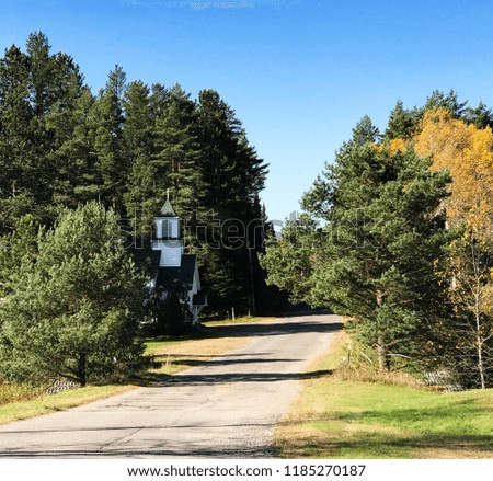 Fall autumn landscape with white church and country road.