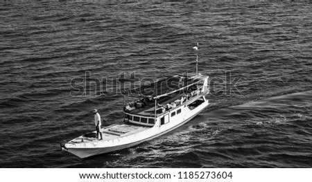 a black and white boat with fisherman on top in middle of sea in karimun jawa indonesia Royalty-Free Stock Photo #1185273604
