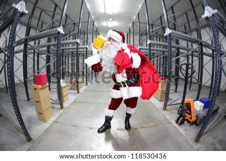Santa Claus preparing for Christmas,selecting presents  in empty storehouse, fish-eye photo