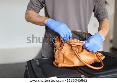 A Customs at airport doing security check of hand baggage Royalty-Free Stock Photo #1185345862