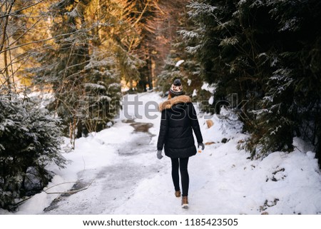 Girl doing hiking in the snow-covered mountains in winter
