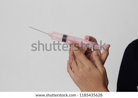 A hand holding a dropper for science experiment or as baby liquid feeding.