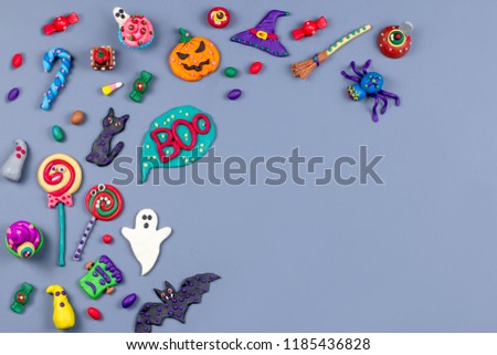 Halloween background with decorations. Black cat, bats, witches hat and broomstick with orange pumpkins. Top view