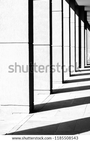 Shadows on modern columns on the floor as abstract art. Black and white image.