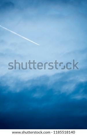 The airplane flies in the blue sky, the exhaust pulls out a line, beautiful background picture.