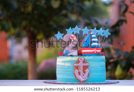 beautiful cake for the birthday of a child with the number two and a ship anchor in the summer garden