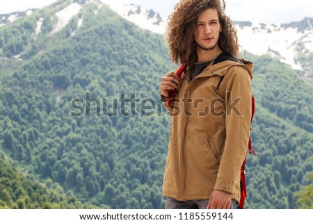 Man Traveler with yellow parka and red backpack hiking outdoor. Travel, Lifestyle, vacation and Adventure concept