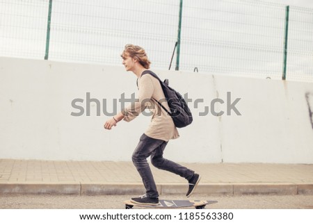 Sports Man skateboarding in Park in summer morning. man rides longboard