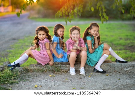 boy and three girls in clothes with a picture in a cage rest on the street