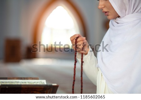 Crop Muslim woman with string of beads Royalty-Free Stock Photo #1185602065