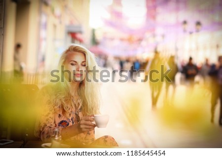 blond woman on lunch break sit in summer outdoor cafe with cup of coffee close up photo