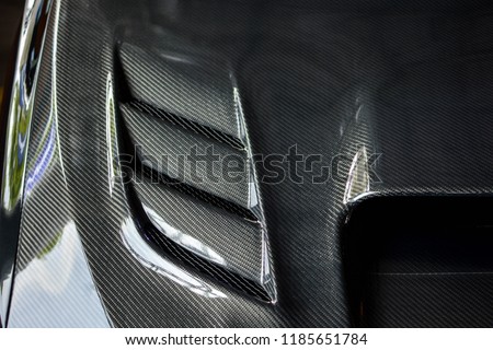 Photo of a modified carbonized car hood vents. Front view of a modified luxury car.