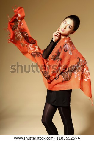 Asian girl wearing silk scarf over yellow background