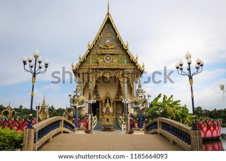The Thai temple in Wat Plai Laem in Samui Island Thailand, in the middle of the water, contains giant statues and elephants.Pigeon flies through.