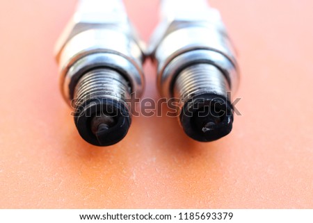 Two spark plugs from the motorcycle, covered with a layer of soot, the consequences of burning fuel of poor quality.
