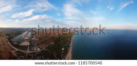 Aerial drone panoramic photo of famous sports rowing and canoeing center in iconic beach of Schoinias with beautiful scattered clouds and blue sky, Marathon, Attica, Greece