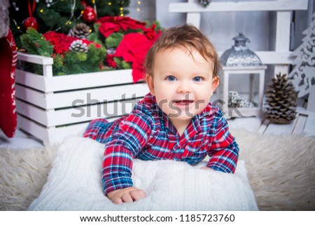 Portrait of a cute kid in a red checkered shirt on a Christmas background