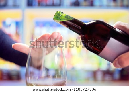 Woman refusing more alcohol from wine bottle in bar Royalty-Free Stock Photo #1185727306