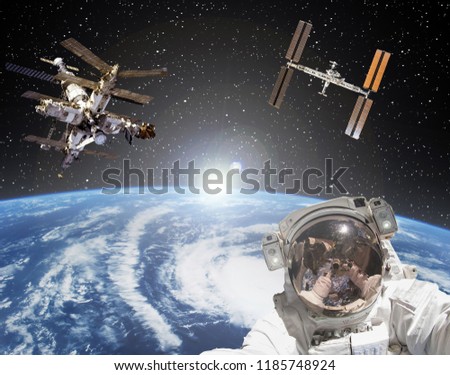 Astronaut, space stations and sunrise on the backdrop. The elements of this image furnished by NASA.

