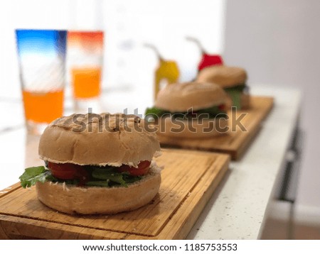 
homemade burgers with cheese and bacon on wooden boards and french fries