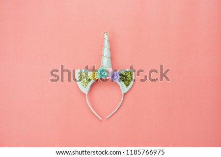 Table top view aerial image of fantasy object background concept.Flat lay cute of unicorn headband on modern rustic of pink paper.Creative pastel tone design.