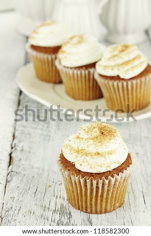 Pumpkin spice cupcakes frosted with cream cheese icing and sprinkled with brown sugar. Shallow depth of field.