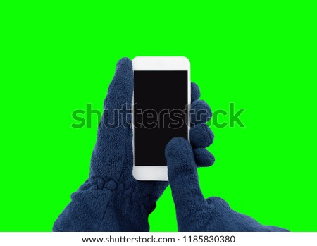 hand with glove holding a smart phone  in winter and isolated cutout on green background with chroma key