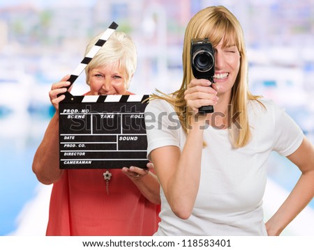 Two Happy Woman Holding Clapper Board And Camera, Outdoor